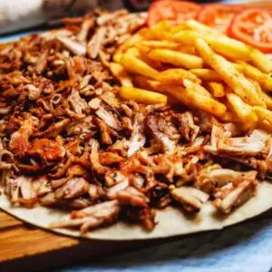 דוכן שווארמה לאירועים - שווארמה קצוצה דק עם ציפס בצד על מגש עץ מעוצב מאסטרים לאירועים